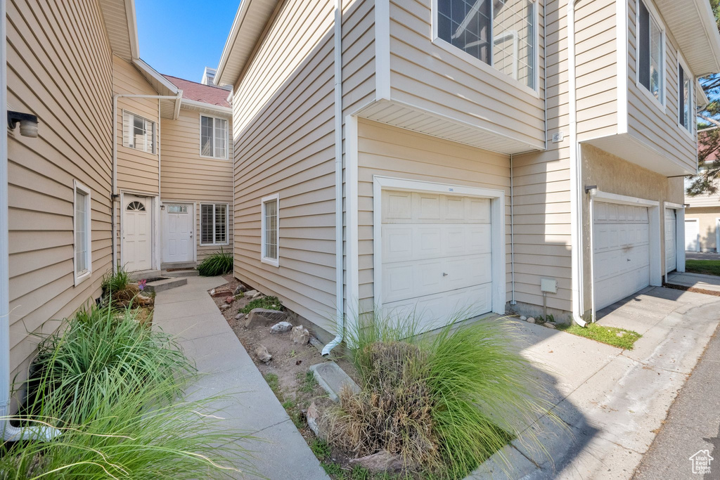 View of side of home with an attached garage and driveway