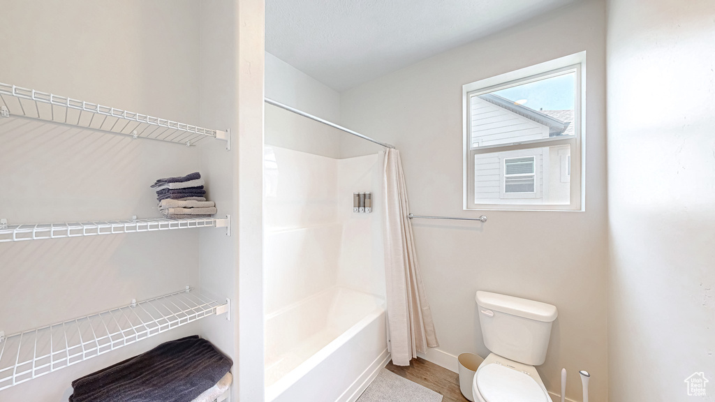 Bathroom featuring shower / bath combo with shower curtain and wood finished floors