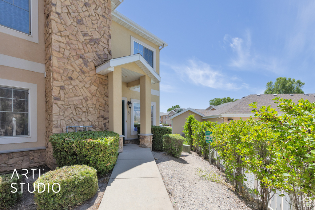 Property entrance with stone siding and stucco siding