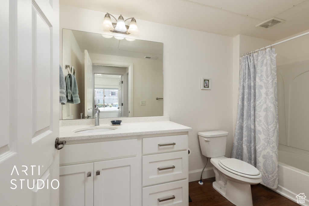 Bathroom featuring vanity, wood finished floors, and shower / tub combo with curtain