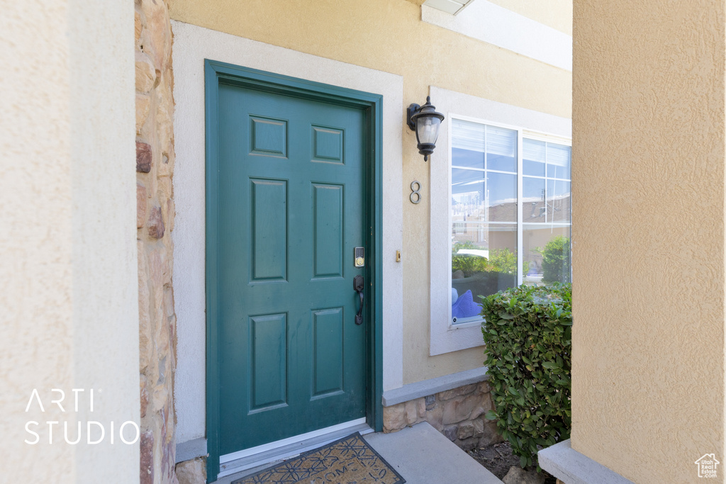 Property entrance featuring stucco siding and stone siding
