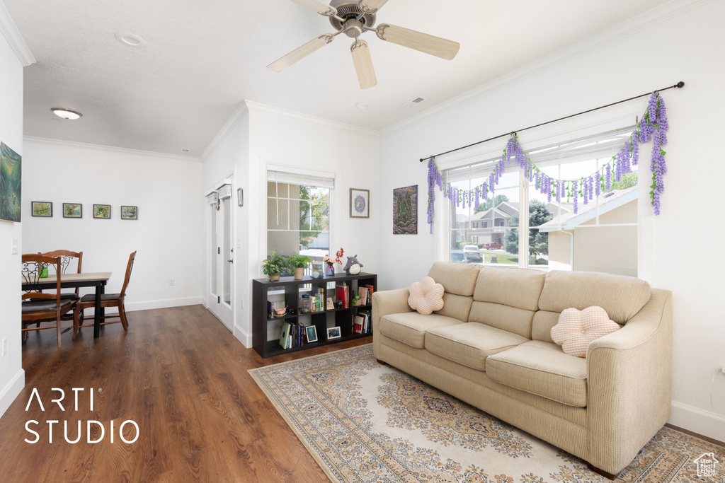 Living area with dark wood-style floors, ornamental molding, and a ceiling fan