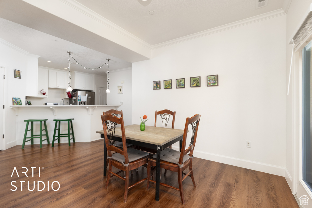 Dining room featuring ornamental molding and dark wood-type flooring