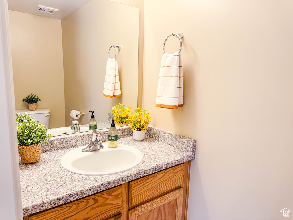 Half bathroom with vanity and toilet
