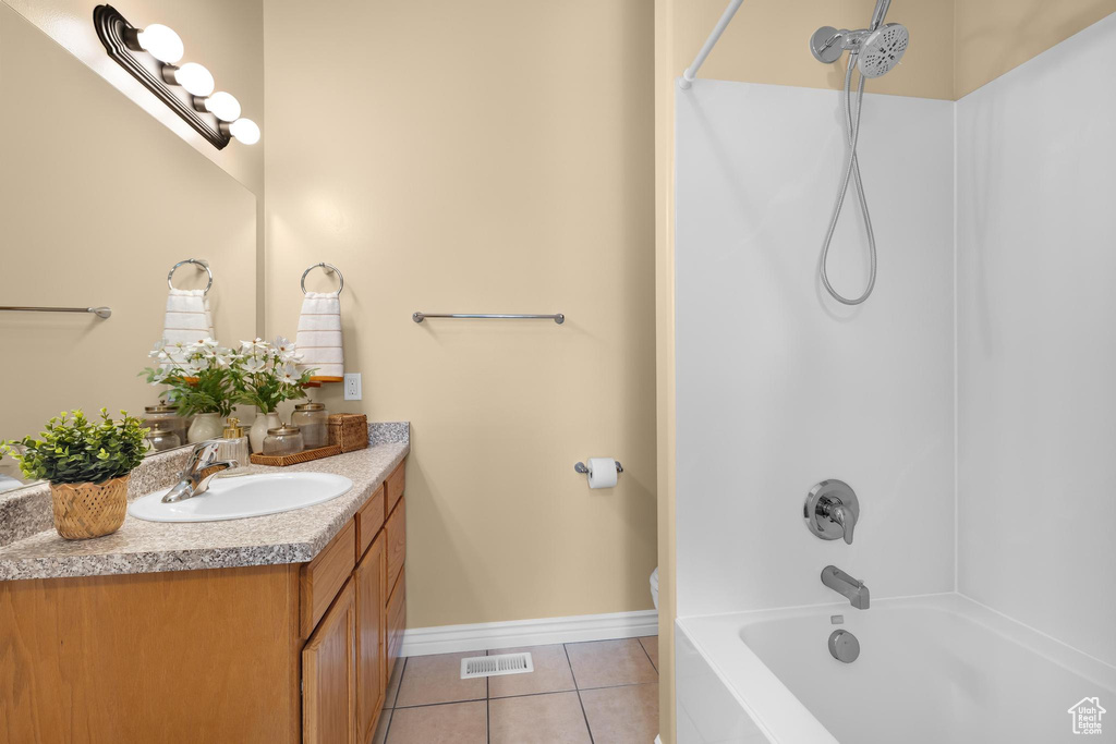 Full bathroom featuring vanity, tile patterned floors, and washtub / shower combination