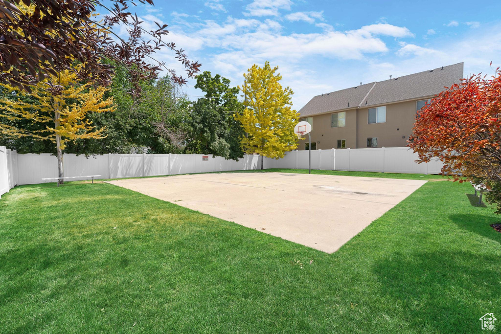 Fenced backyard with community basketball court