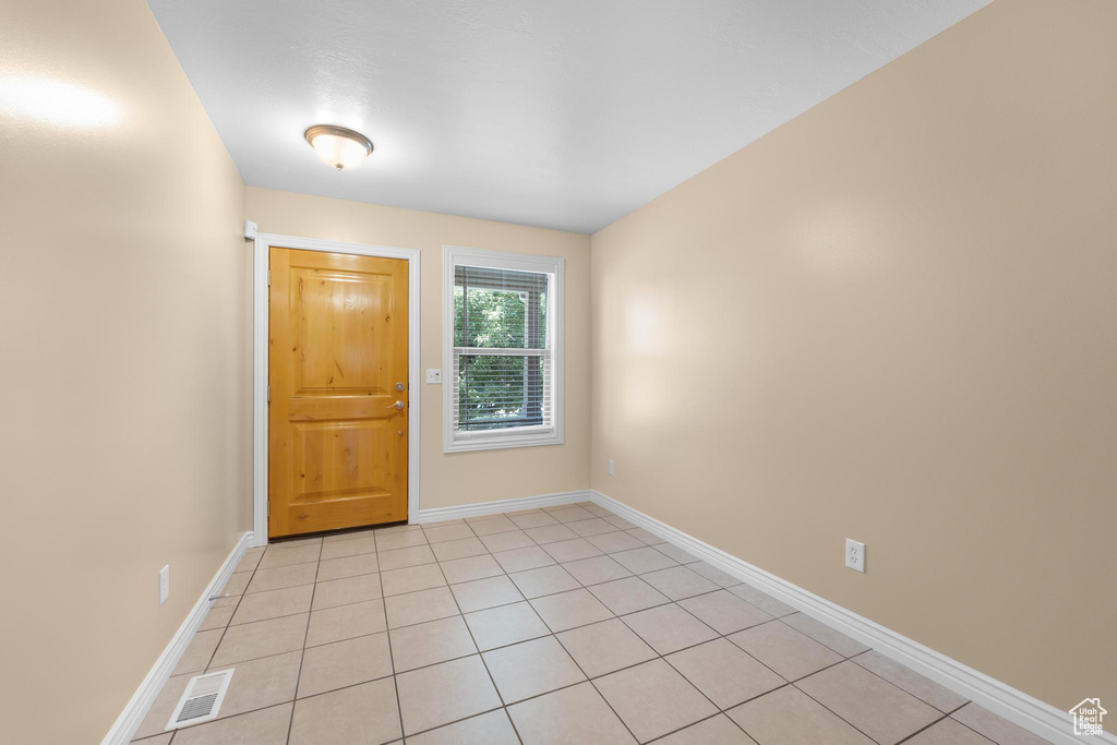 Foyer with baseboards and light tile patterned flooring