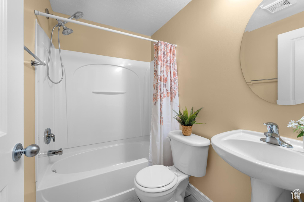 Bathroom featuring shower / bath combo and a sink