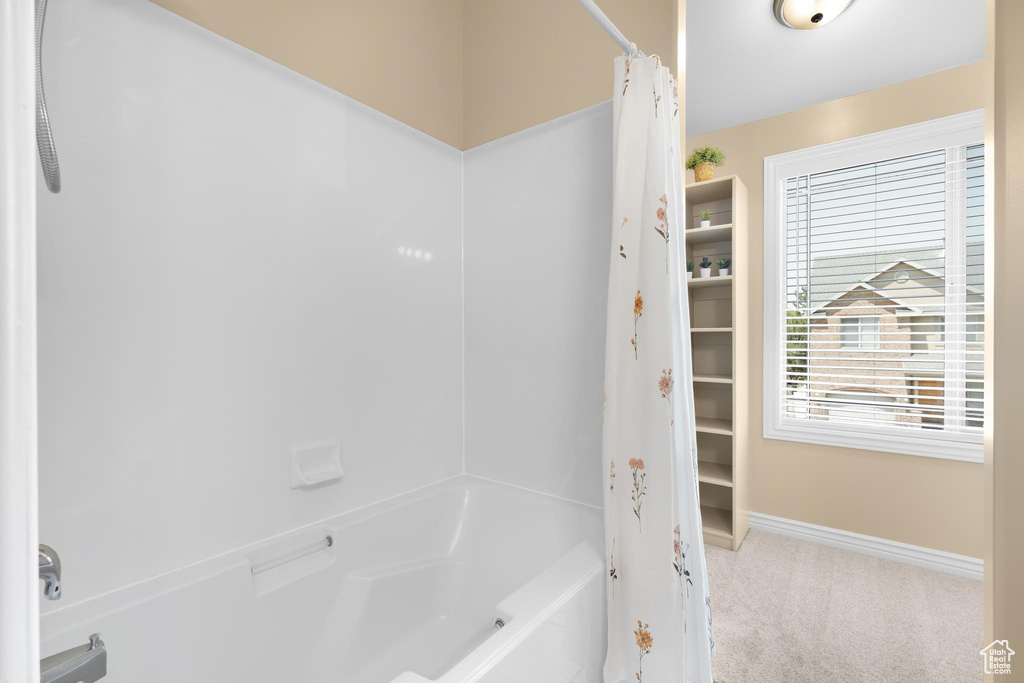Bathroom with baseboards and shower / bath combo with shower curtain