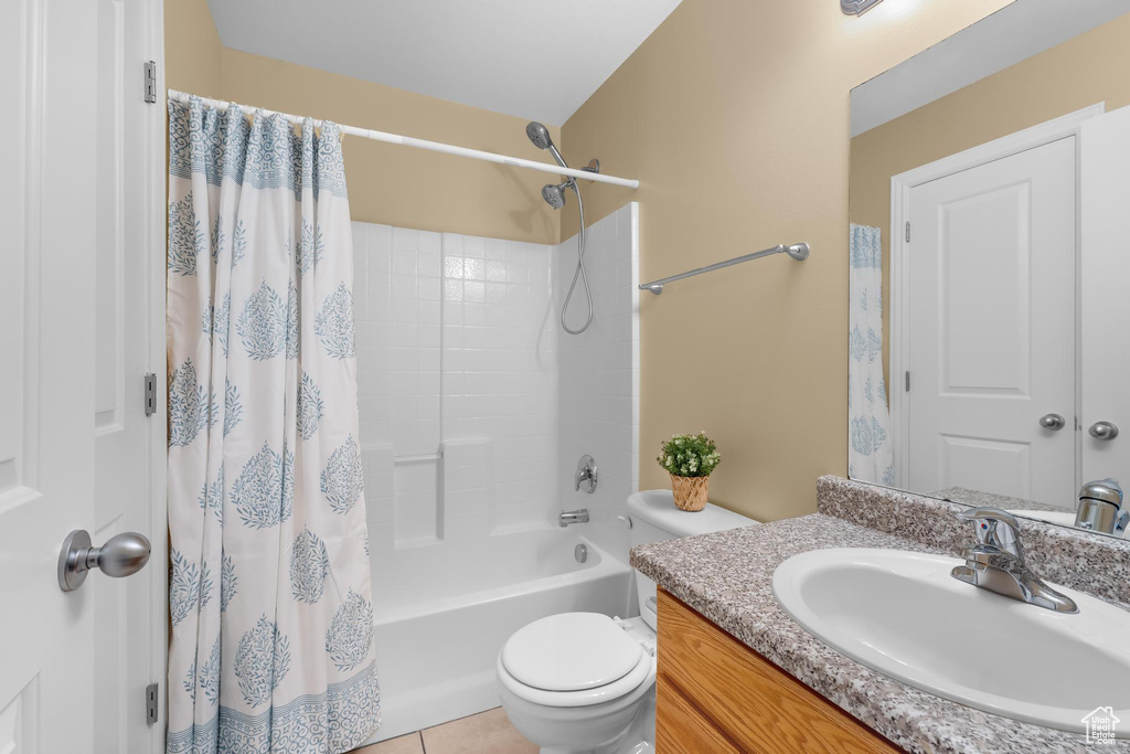 Bathroom featuring vanity, shower / tub combo with curtain, and tile patterned floors