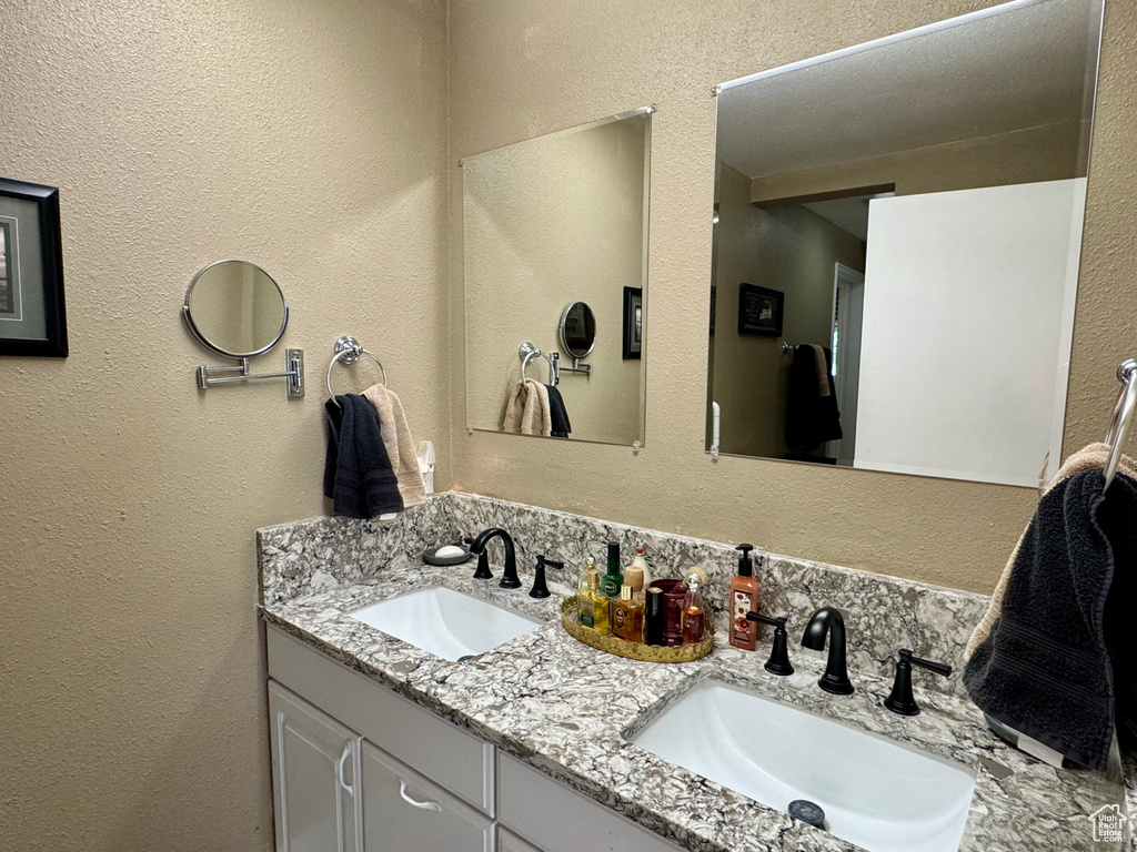 Bathroom with double vanity and a textured wall