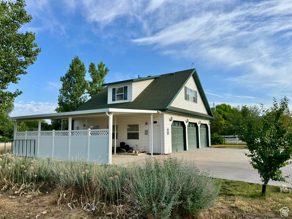 View of front of home featuring driveway, a porch, and roof with shingles