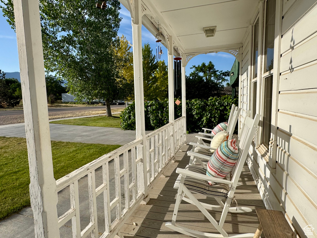 Wooden porch featuring a lawn