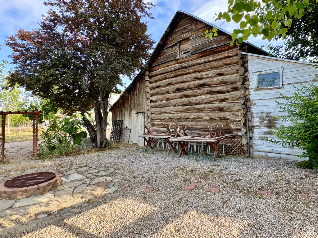 View of home\\\\\\\'s exterior with an outdoor fire pit and log siding