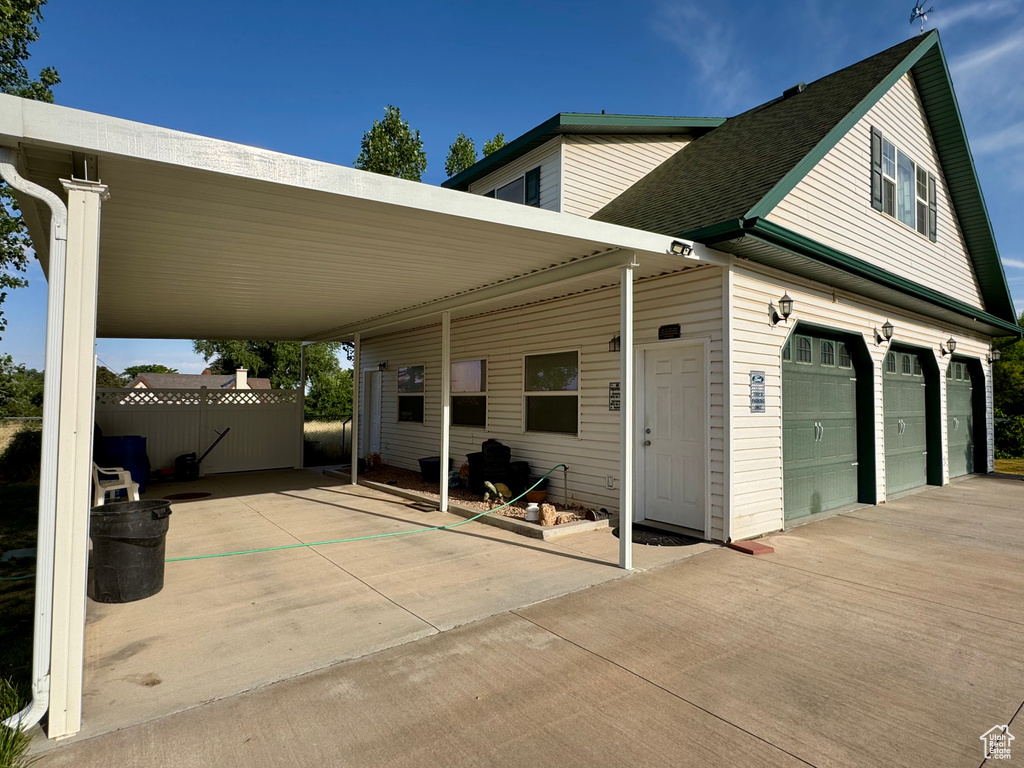 View of patio featuring concrete driveway and a garage