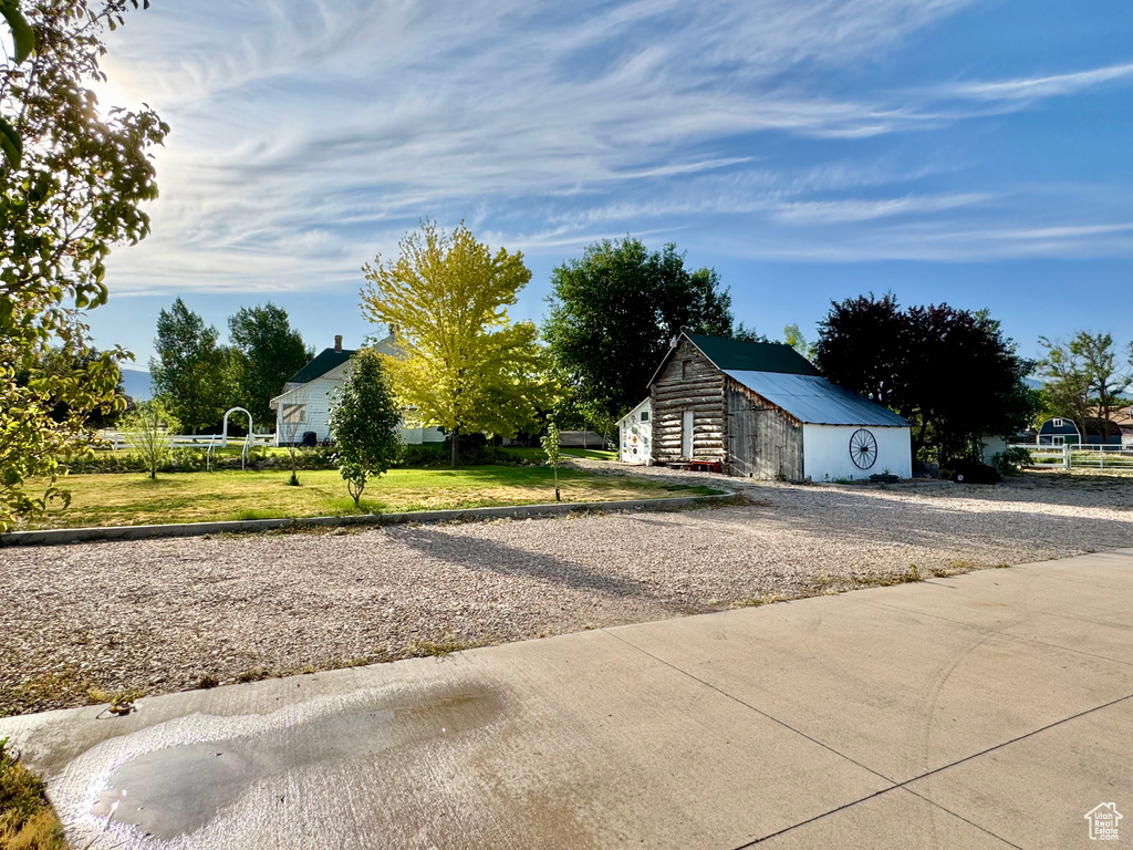 View of front of property with an outdoor structure, a front yard, and a metal roof