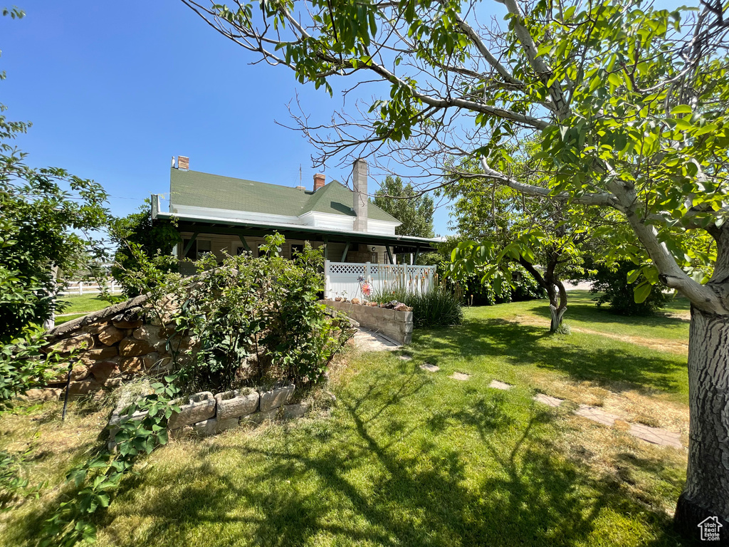View of grassy yard featuring covered porch