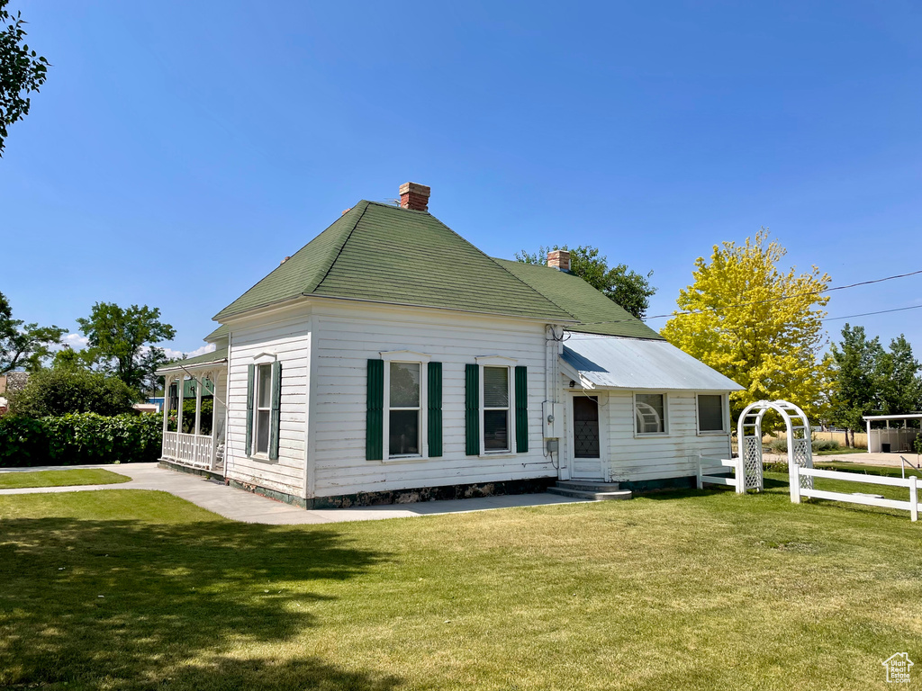 View of front facade featuring a chimney, a front yard, and entry steps