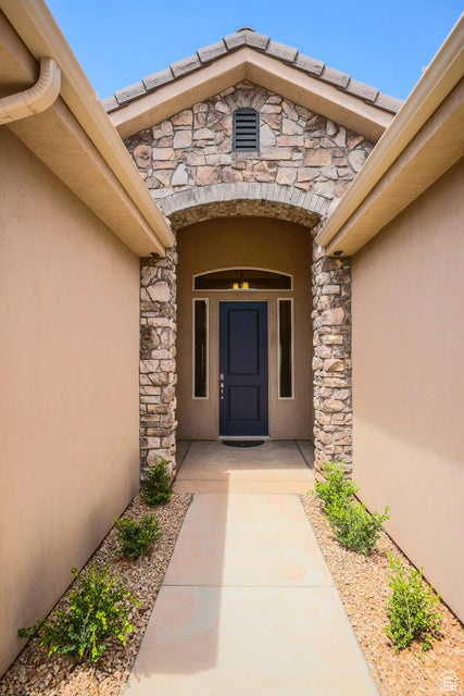 Property entrance featuring stone siding and stucco siding