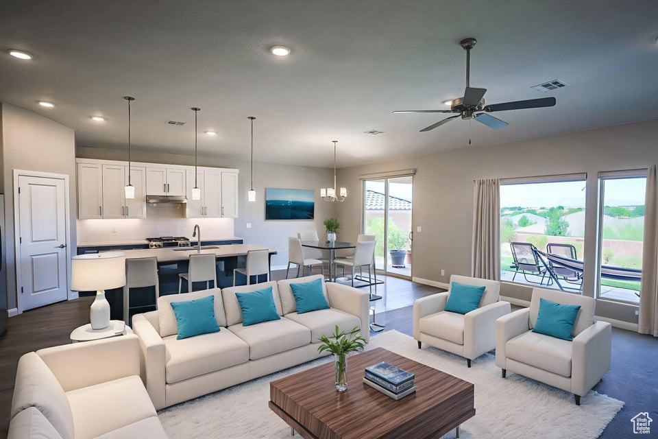 Living area featuring ceiling fan, recessed lighting, wood finished floors, and a chandelier