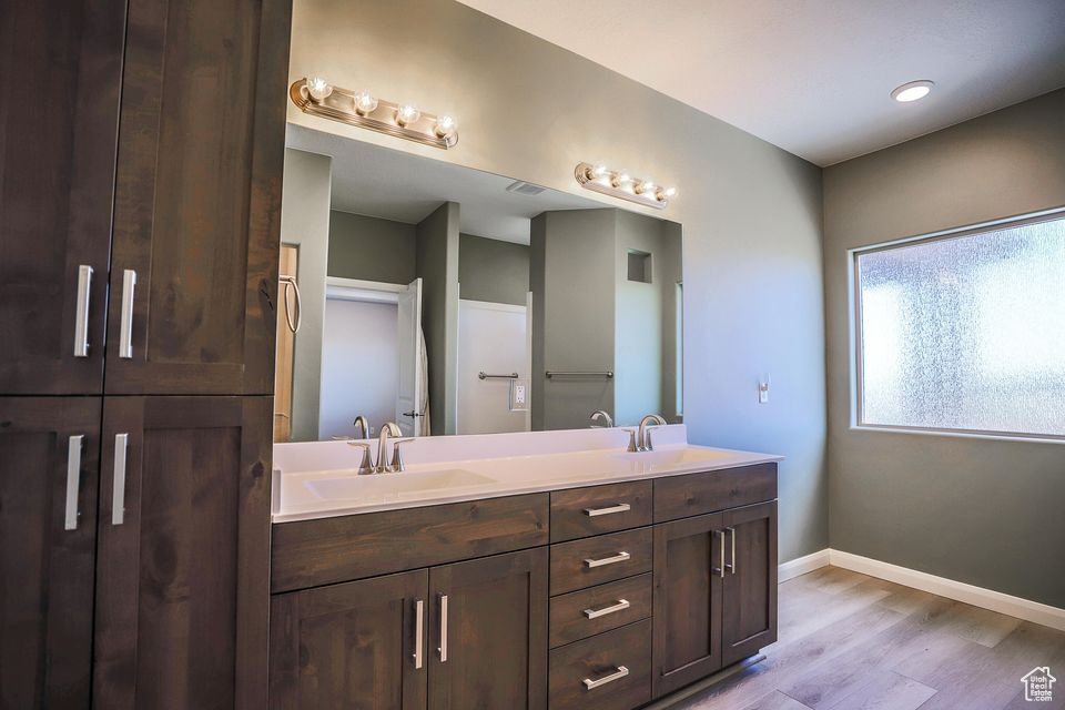 Bathroom with double vanity and wood finished floors