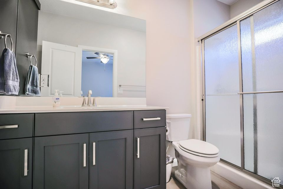 Bathroom with vanity, a stall shower, and ceiling fan