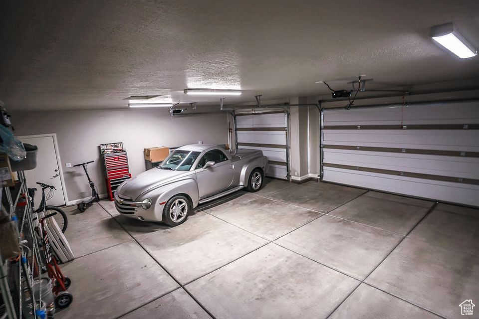 Garage featuring a garage door opener and baseboards