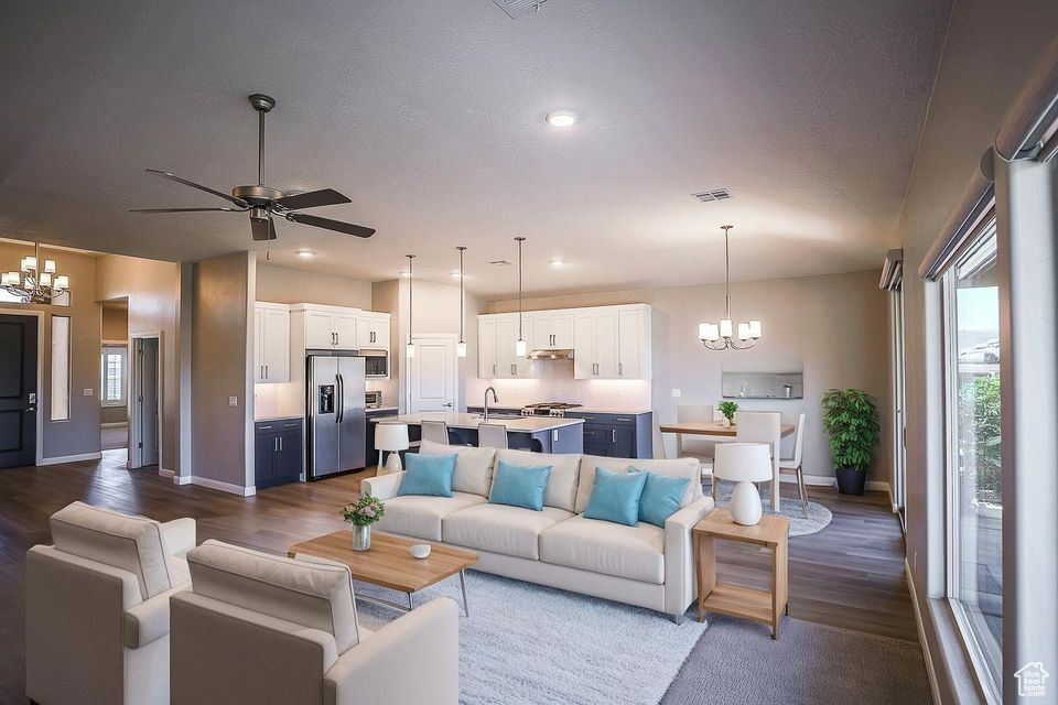 Living room with a chandelier, dark wood-style floors, ceiling fan, and recessed lighting