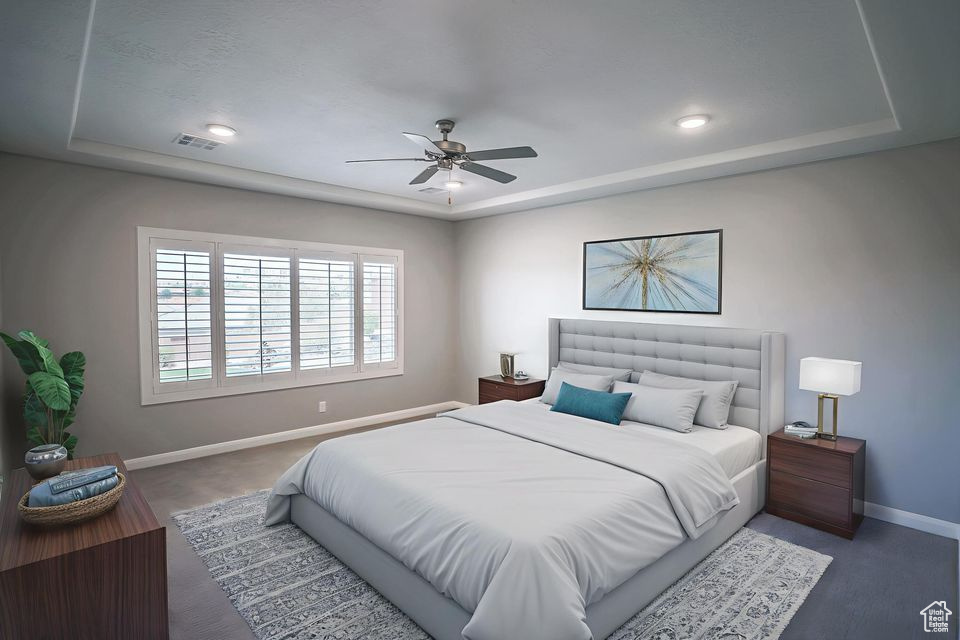 Bedroom with a raised ceiling, ceiling fan, and recessed lighting