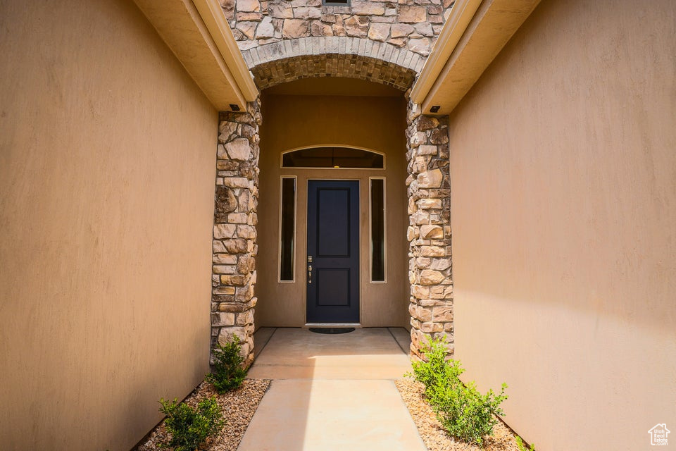 Doorway to property with stone siding and stucco siding