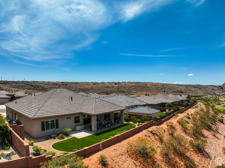 Back of property featuring a fenced backyard, a patio area, stucco siding, and a tile roof