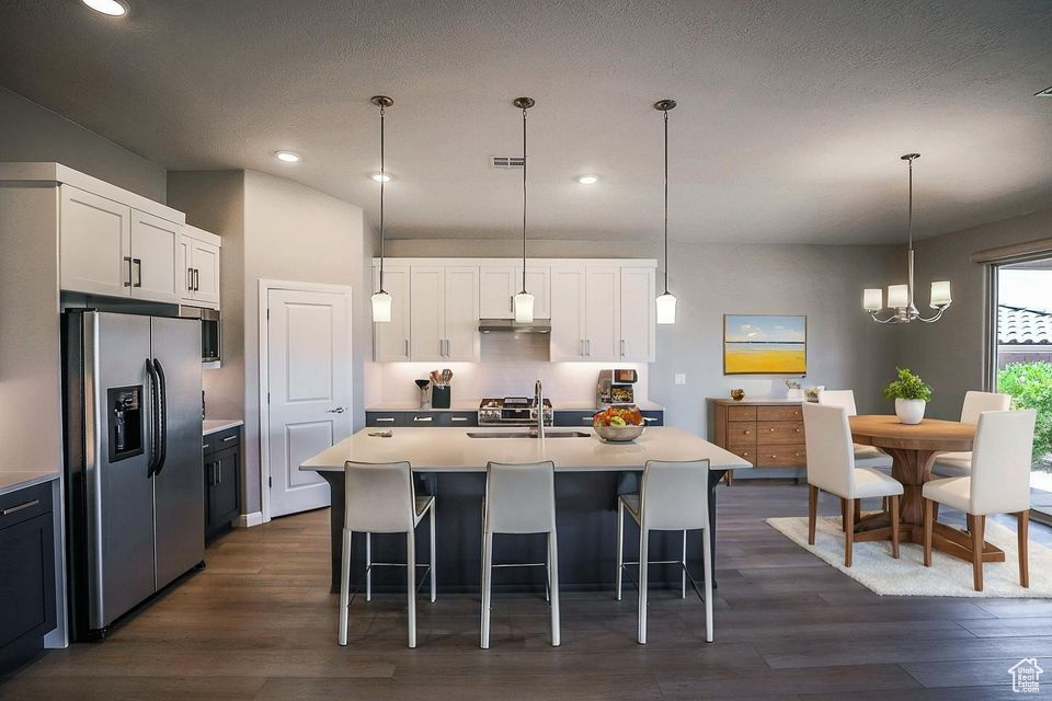 Kitchen featuring stainless steel refrigerator with ice dispenser, dark wood-type flooring, light countertops, white cabinetry, and recessed lighting