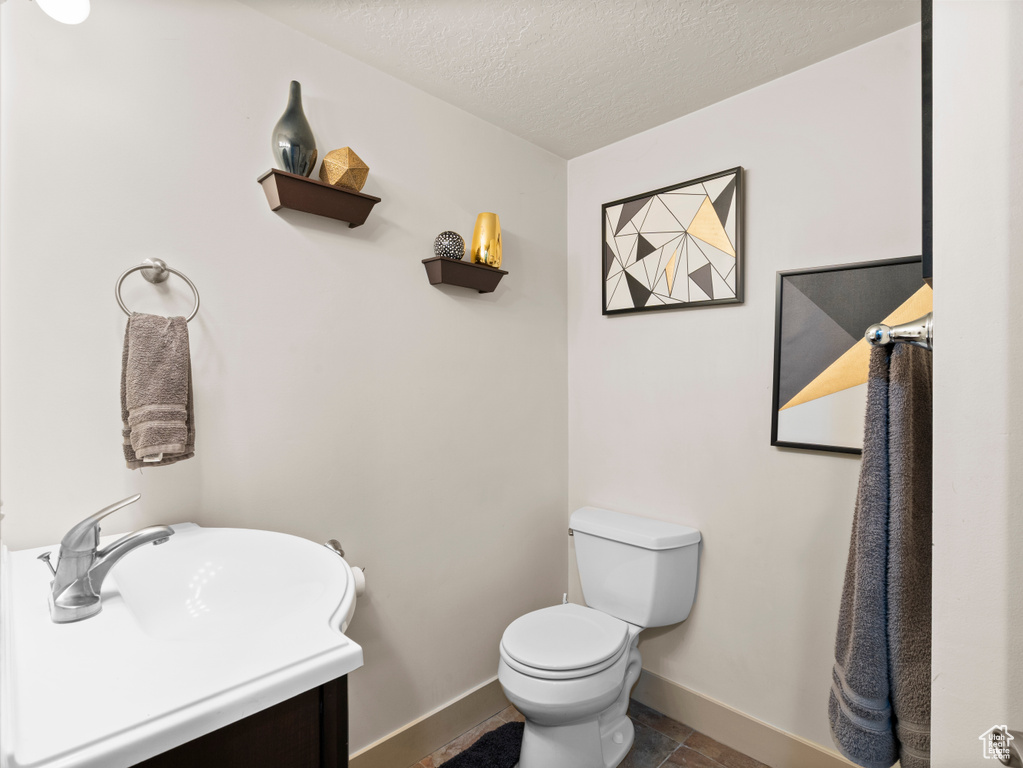 Bathroom with toilet and a textured ceiling