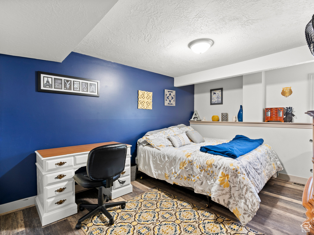 Bedroom featuring a textured ceiling and wood finished floors