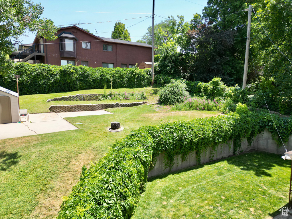 View of green lawn with a patio area