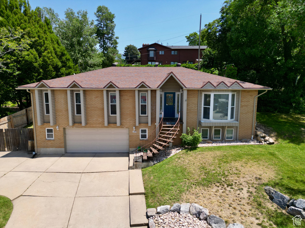 Ranch-style home featuring driveway, an attached garage, and brick siding