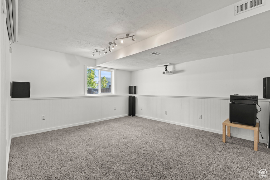 Empty room featuring carpet floors and wainscoting