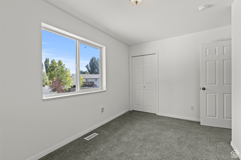 Unfurnished bedroom featuring carpet flooring and a closet
