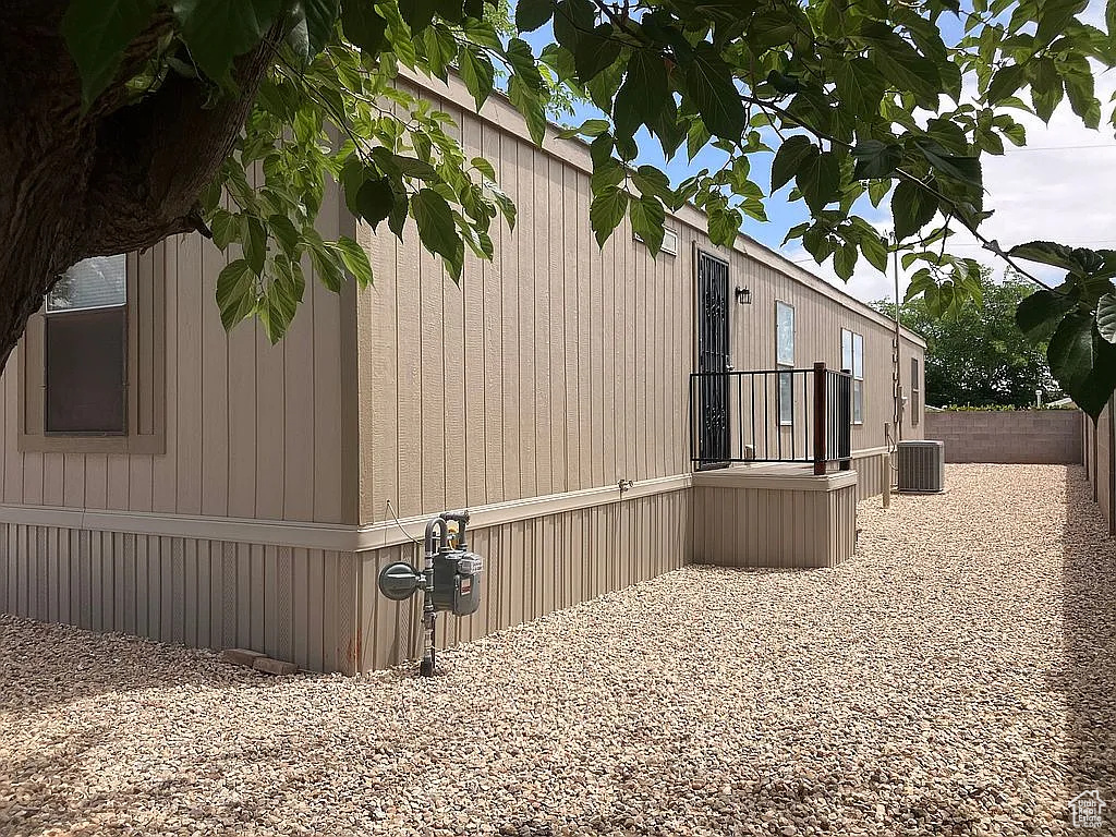 View of side of home with a central air condition unit