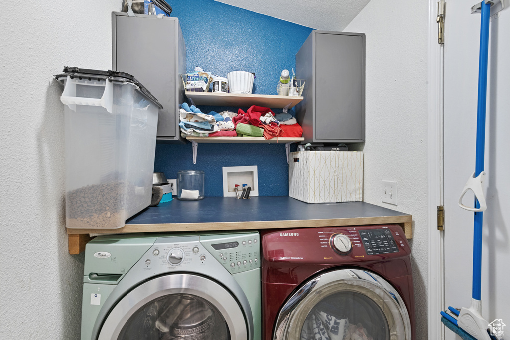 Washroom with washing machine and dryer and a textured wall