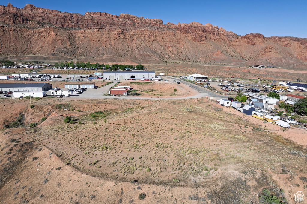 Aerial view of property and surrounding area featuring a mountain backdrop and nearby suburban area