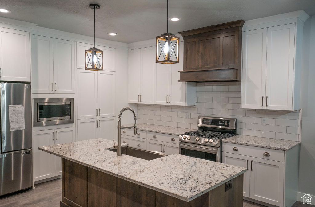 Kitchen with appliances with stainless steel finishes, dark wood-style floors, recessed lighting, tasteful backsplash, and white cabinetry