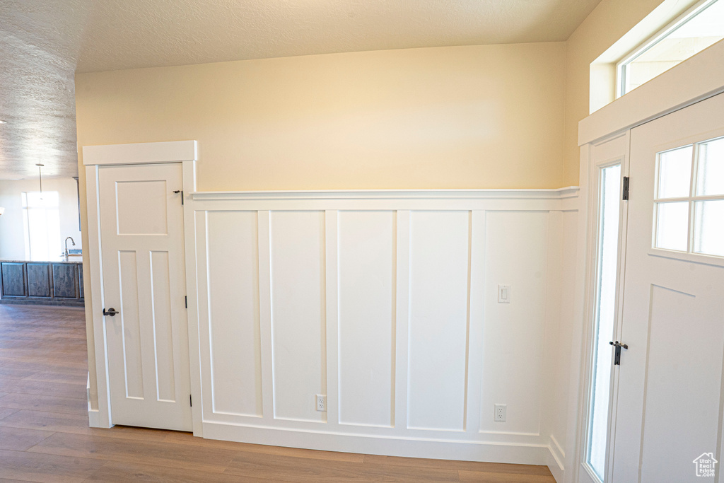 Entrance foyer with a wainscoted wall, wood finished floors, and a decorative wall