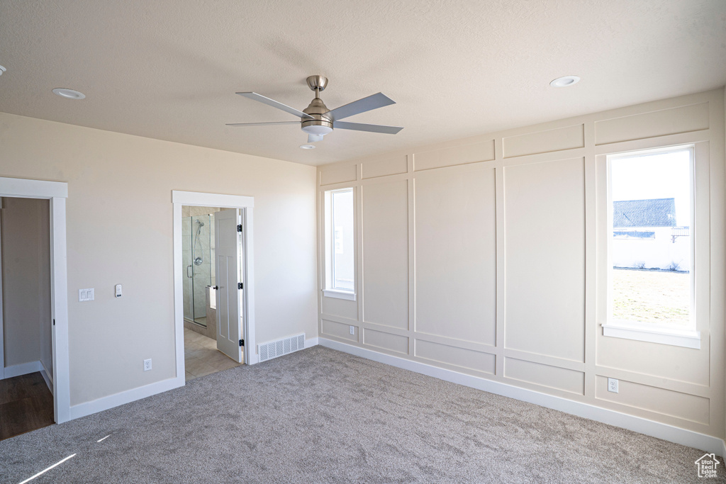 Unfurnished bedroom featuring carpet flooring, a decorative wall, recessed lighting, ensuite bathroom, and a ceiling fan