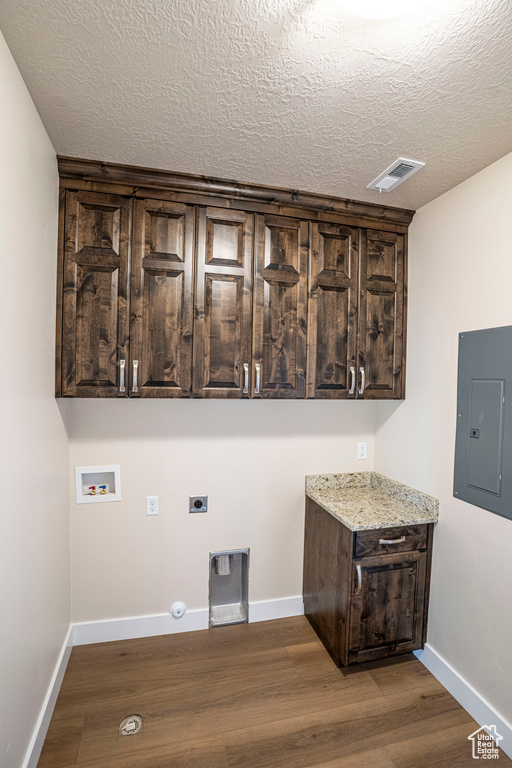 Laundry area with electric panel, electric dryer hookup, cabinet space, washer hookup, and dark wood-style floors