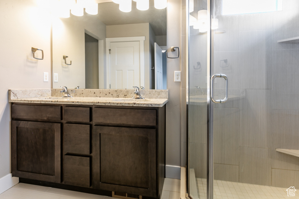 Full bathroom featuring a shower stall and double vanity