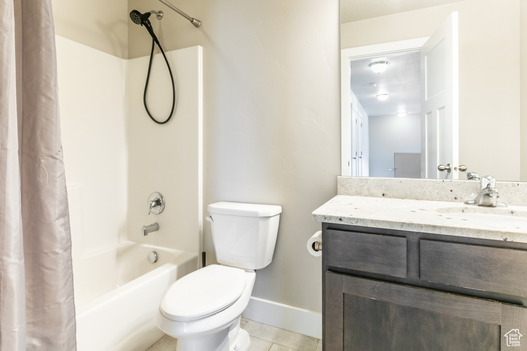 Full bath with shower / tub combo with curtain, vanity, and tile patterned flooring
