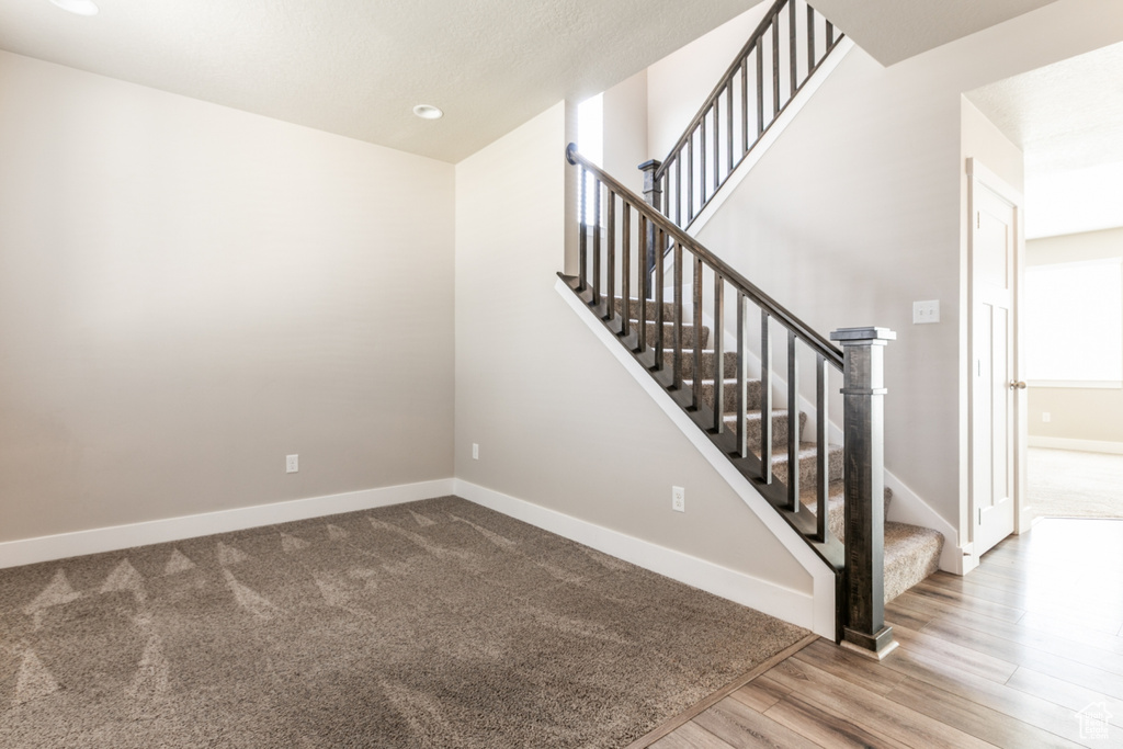 Stairway with wood finished floors and recessed lighting