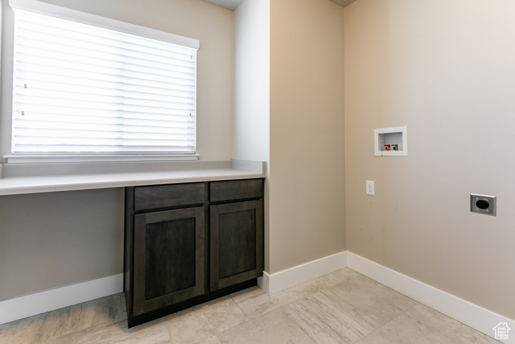 Laundry room with hookup for an electric dryer, hookup for a washing machine, and cabinet space