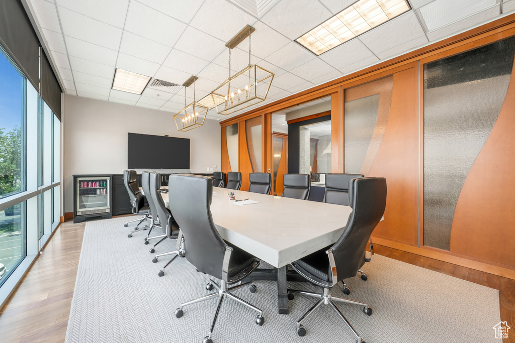 Home office featuring light wood-style flooring, a drop ceiling, and a chandelier